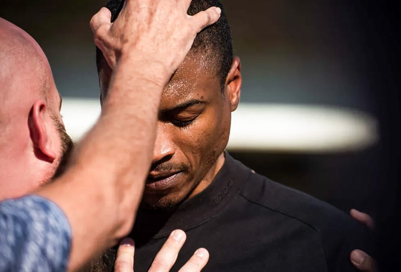 Black man being prayed over